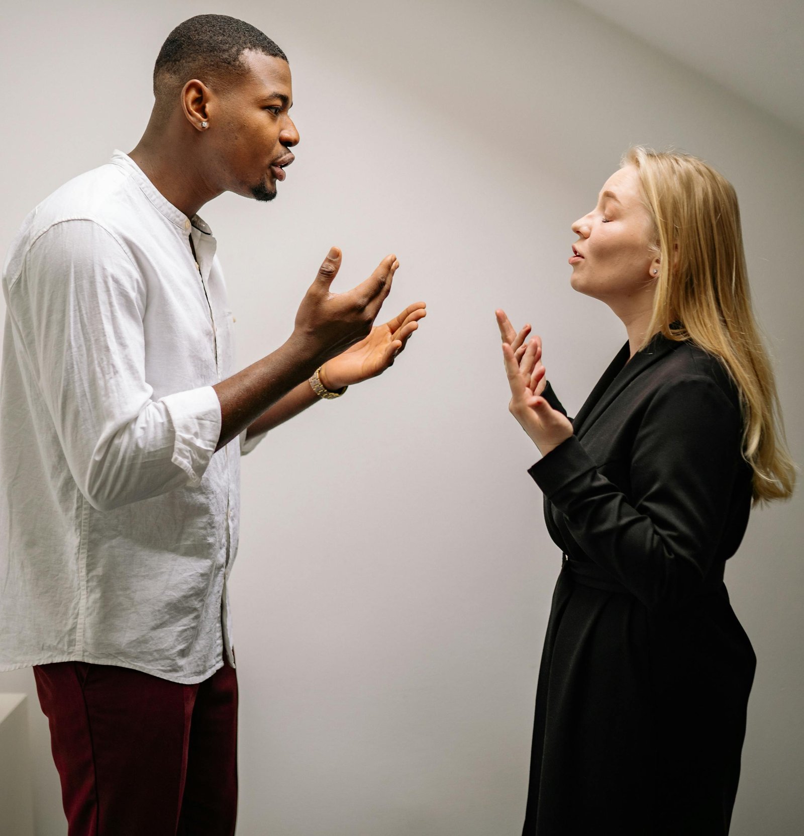 A couple engaged in a heated argument indoors, expressing strong emotions and gestures.